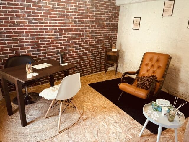 Le cabinet : bureau, fauteuil en cuir et murs de briques